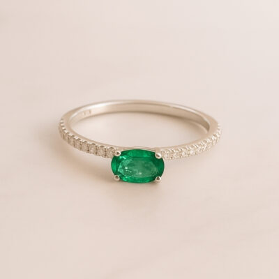 Solitario con esmeralda central y pavé de diamanes en oro blanco 18k